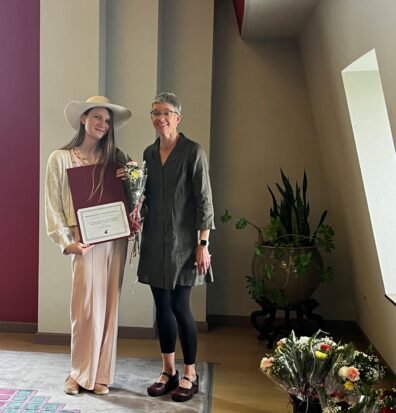 olivia pavek, holding flowers and a certificate, standing next to Julie Kmec