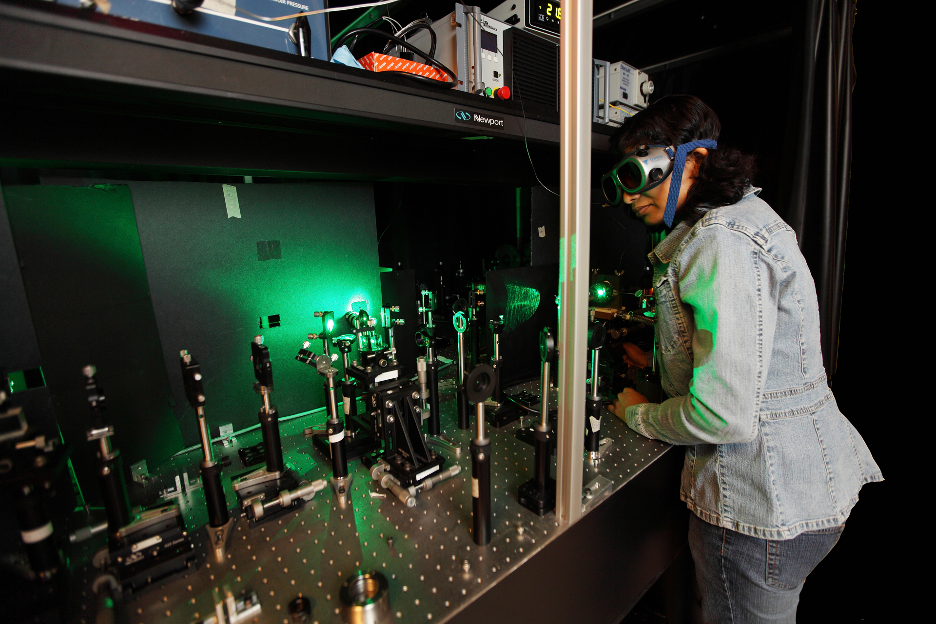 Person wearing safety goggles and working with laser.