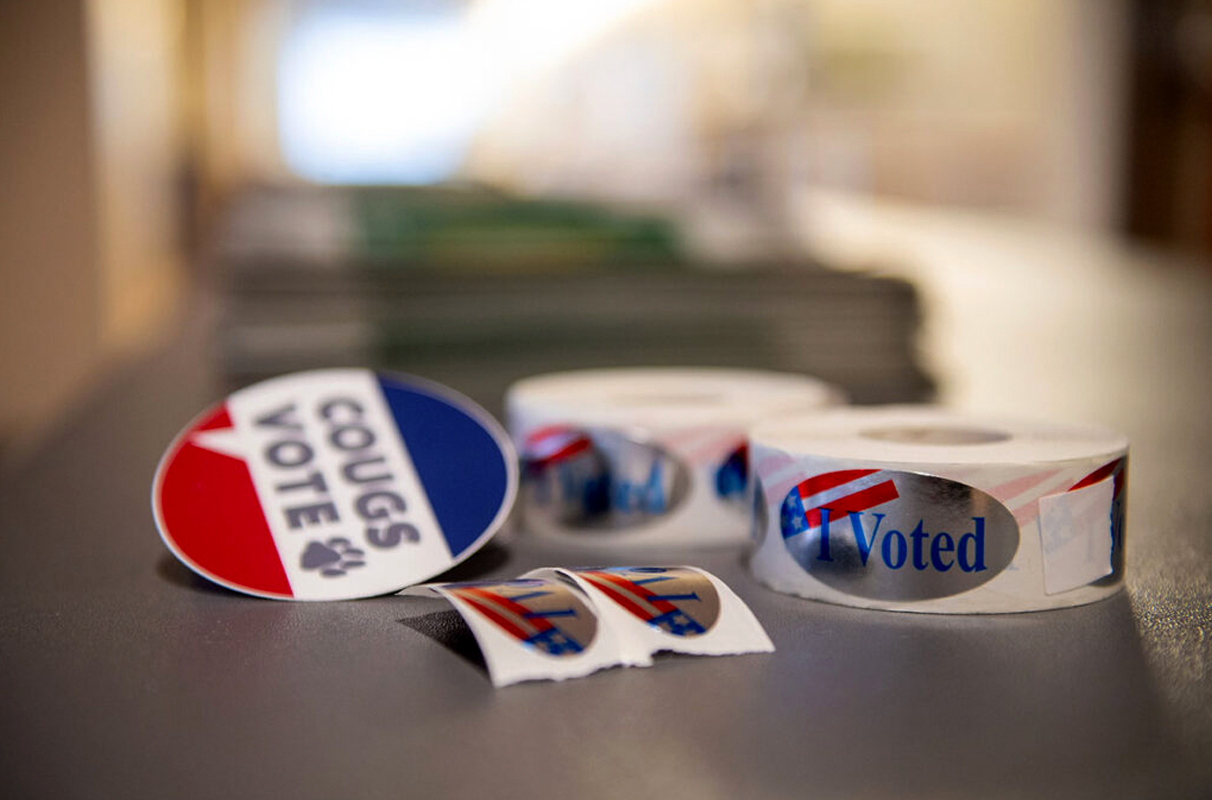 A table with several "Cougs Vote" and "I Voted" stickers.
