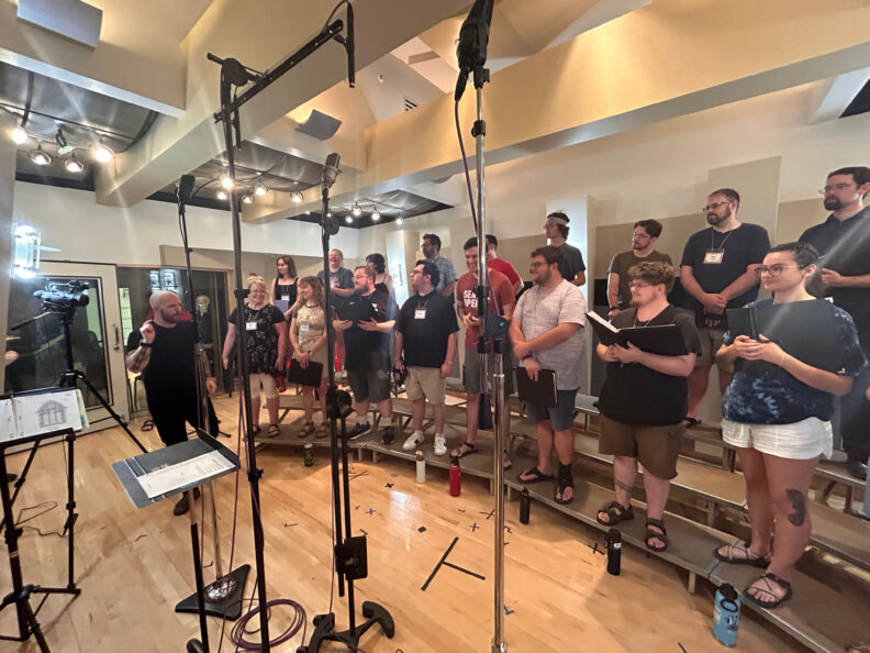 A choral performance being recorded with video camera and microphones.