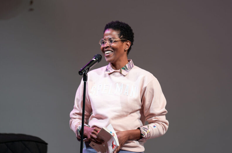 Arisa White speaking in front of a microphone.