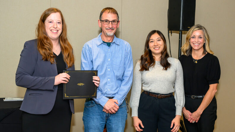 Four people pose for a photo.