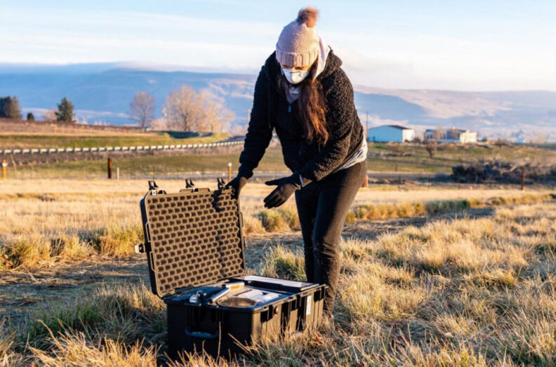 Emily Graham opening a case to collect soil samples near the PNNL campus.