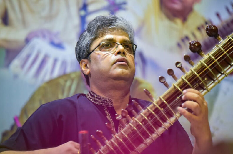Closeup of Anjan Saha playing a sitar.