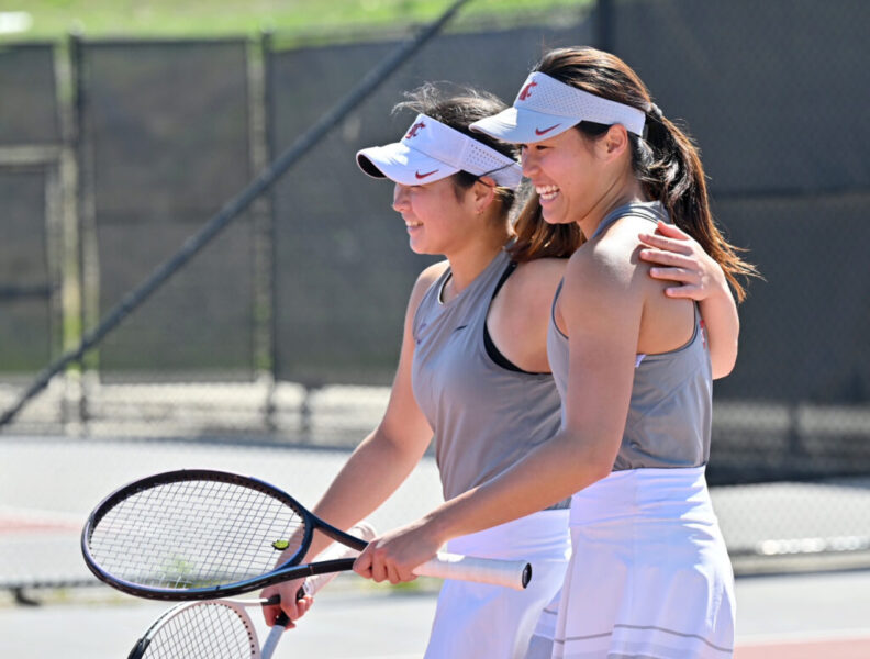 Elyse Tse and a teammate smile as they wrap arms around each other after a WSU tennis match.