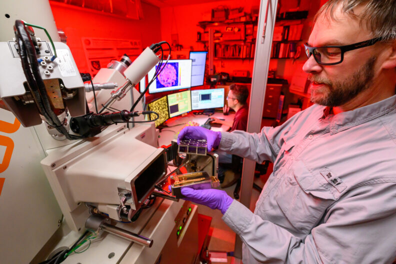 Scott Boroughs loading samples into the electron probe microanalyzer at the Peter Hooper GeoAnalytical Lab (photo by Robert Hubner, WSU Photo Services).
