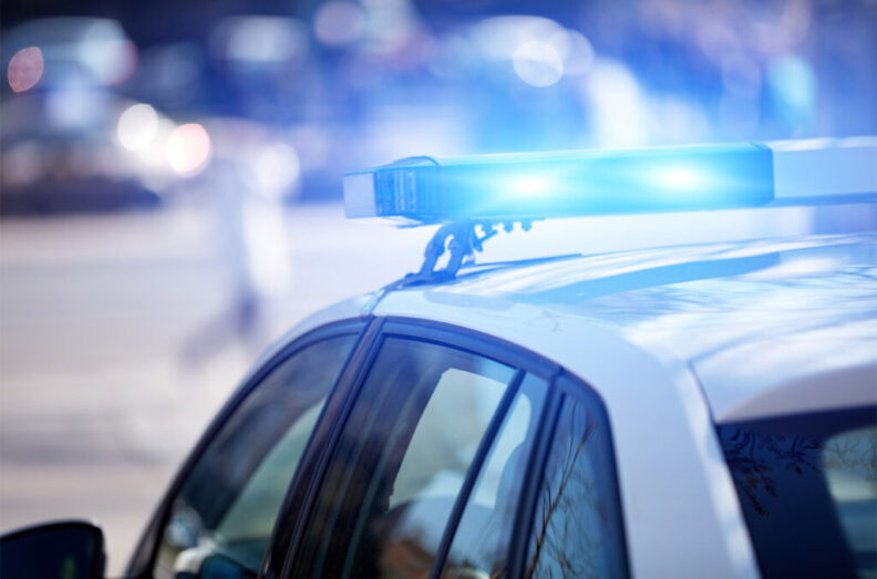 Closeup of a police car with flashing blue lights.