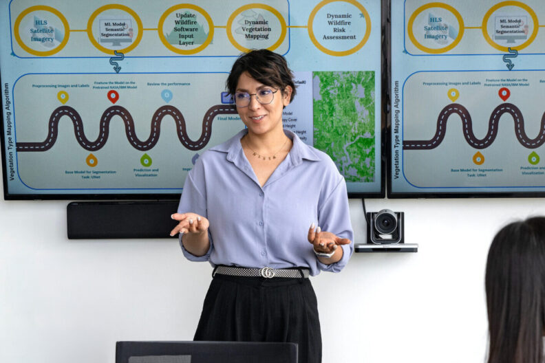 A graduate student presenting in front of a group.