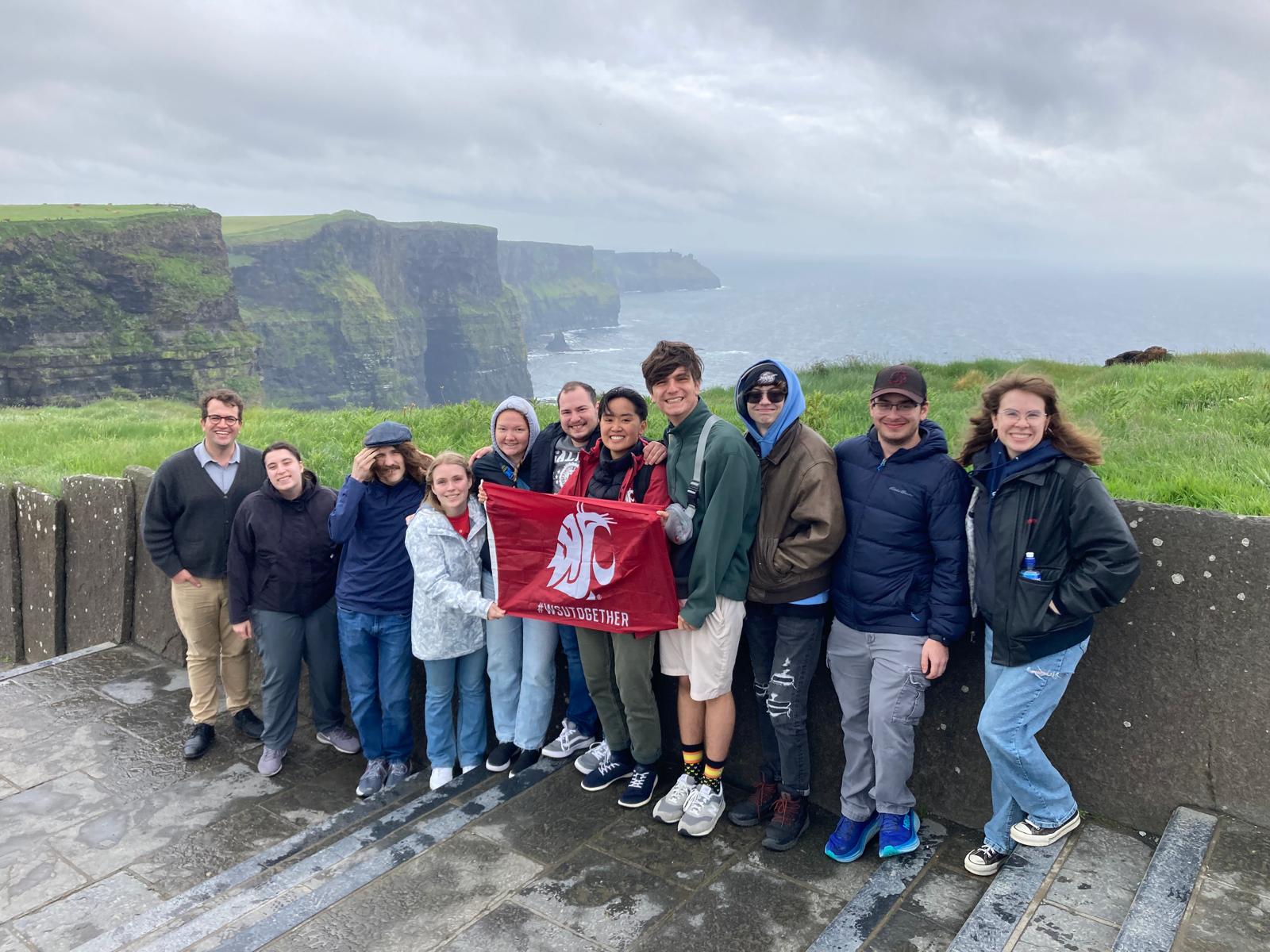 Study abroad students in Ireland holding a cougar spirit flag.