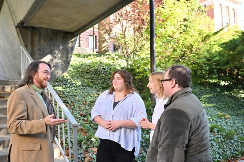 A group of faculty meet outside on the WSU Pullman campus.