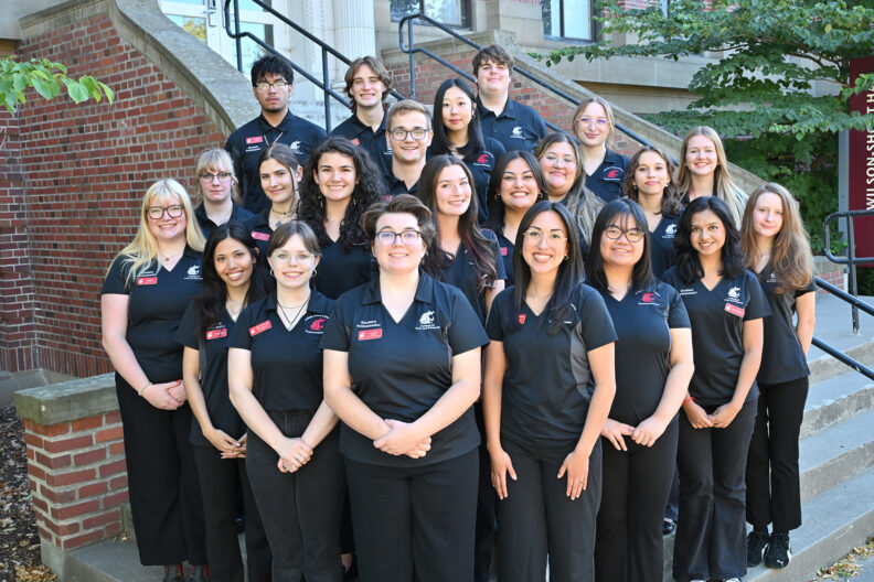 Group of 24 students wearing WSU CAS Student Ambassador shirts in front of Wilson-Short Hall