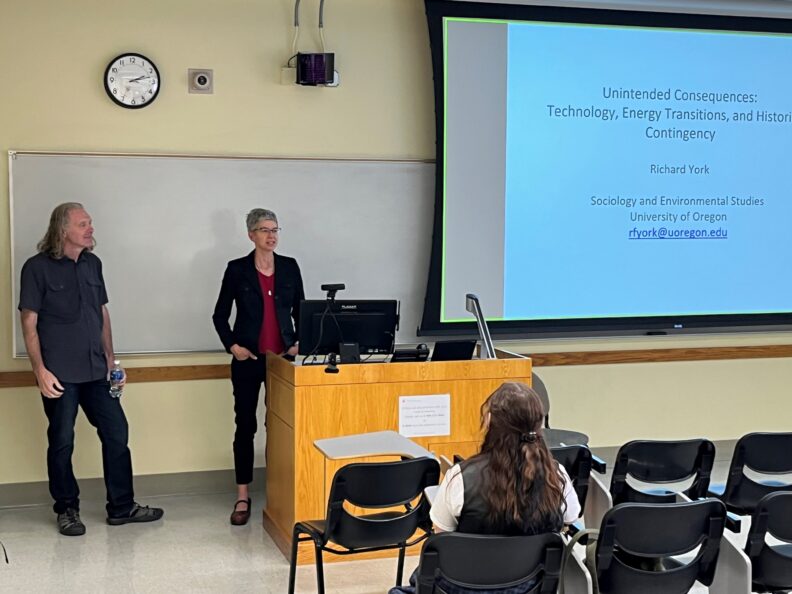 Richard and Julie Kmec stand at the front of a classroom.