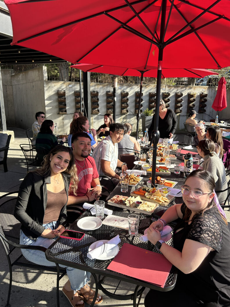 WGSS students out to lunch under a red umbrella.