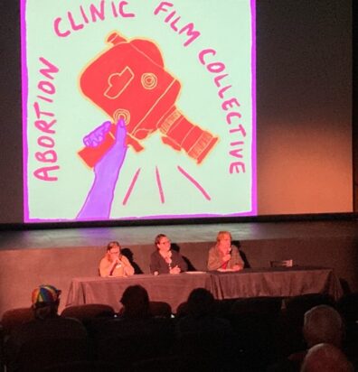 Three panelists on stage at the event.