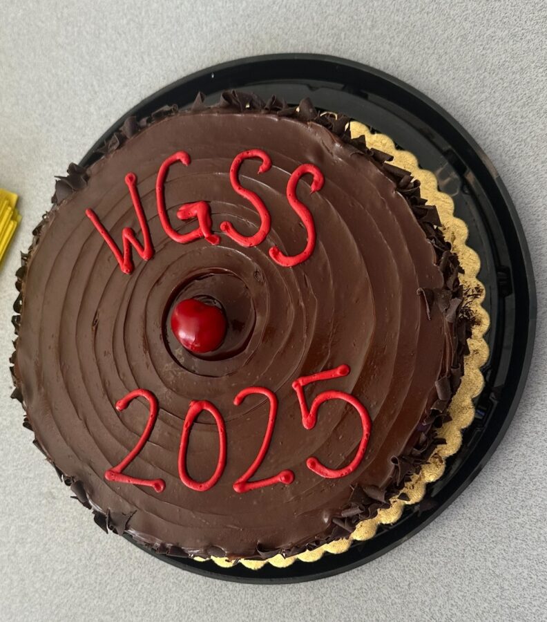 A chocolate frosted cake with a cherry on top that says, "WGSS 2025".