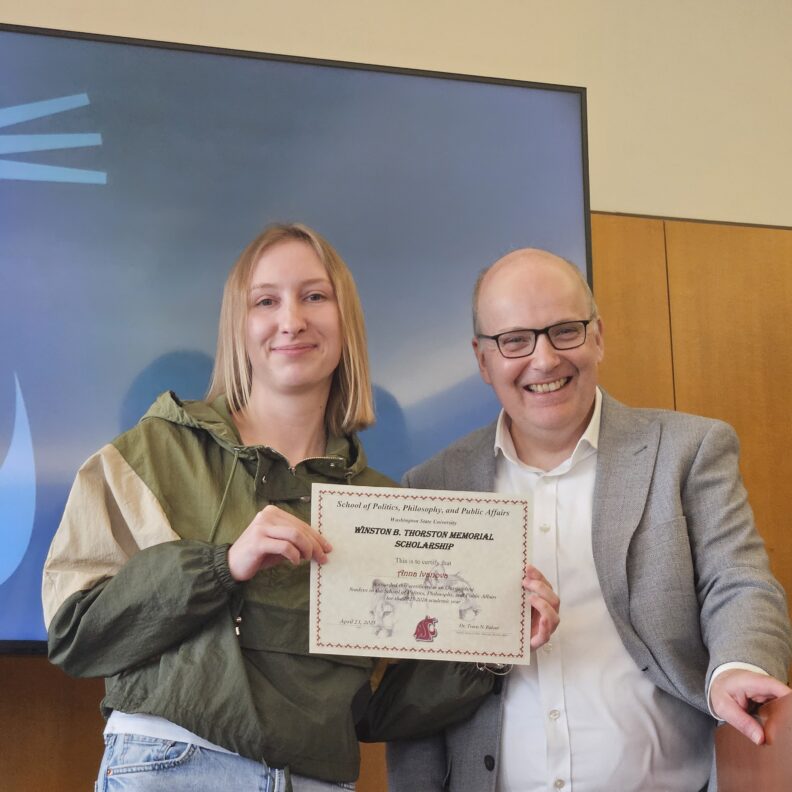 Anna Ivanova holding award with Travis Ridout.