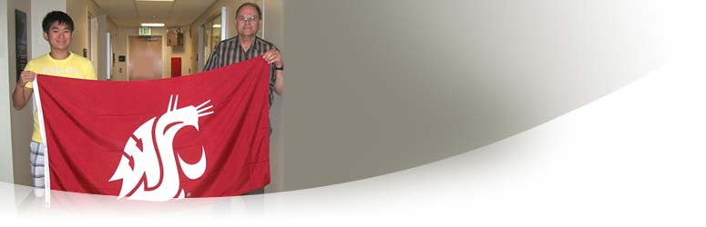 Dr. Pharr and a student holding a WSU Cougar Head flag.