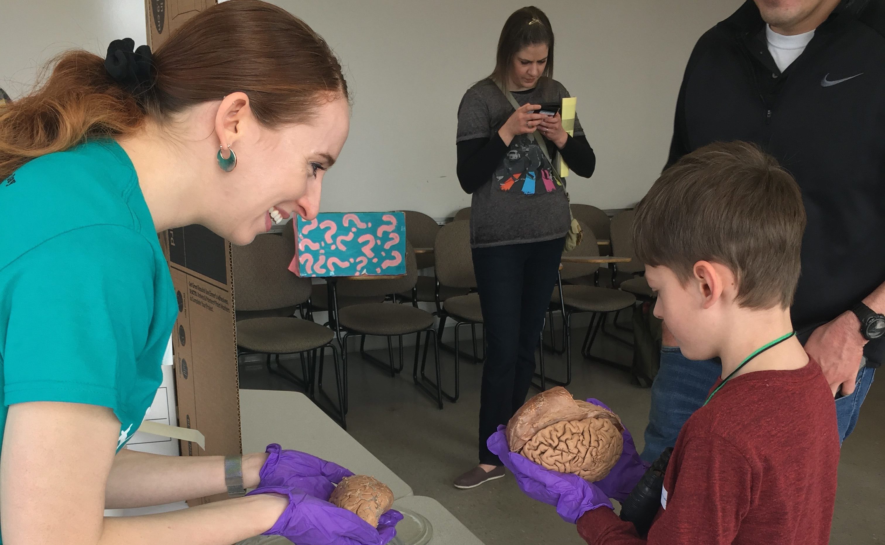 Woman shows a child a brain at a science fair
