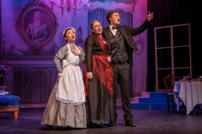 Three people performing Die Fledermaus on stage.