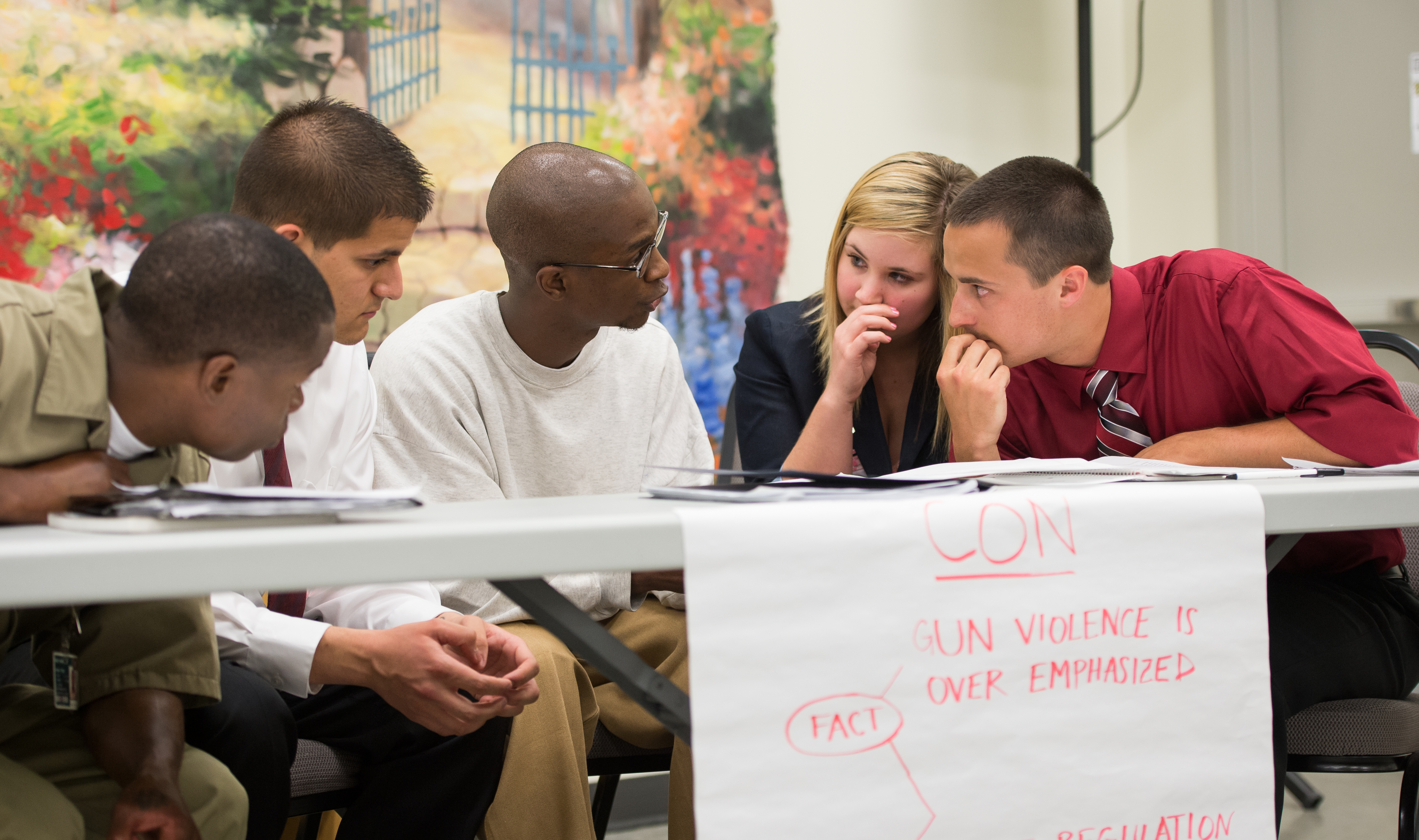 Students meet at a table during Spring 2013 Prisoner Debate Project.