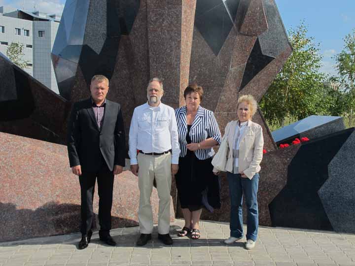 Deputy Head Titarenko, Paul Brians, Deputy Head Tyutyunnyk and Tamara Krasitskaya in front of the base of the Heroes of Chernobyl Memorial.