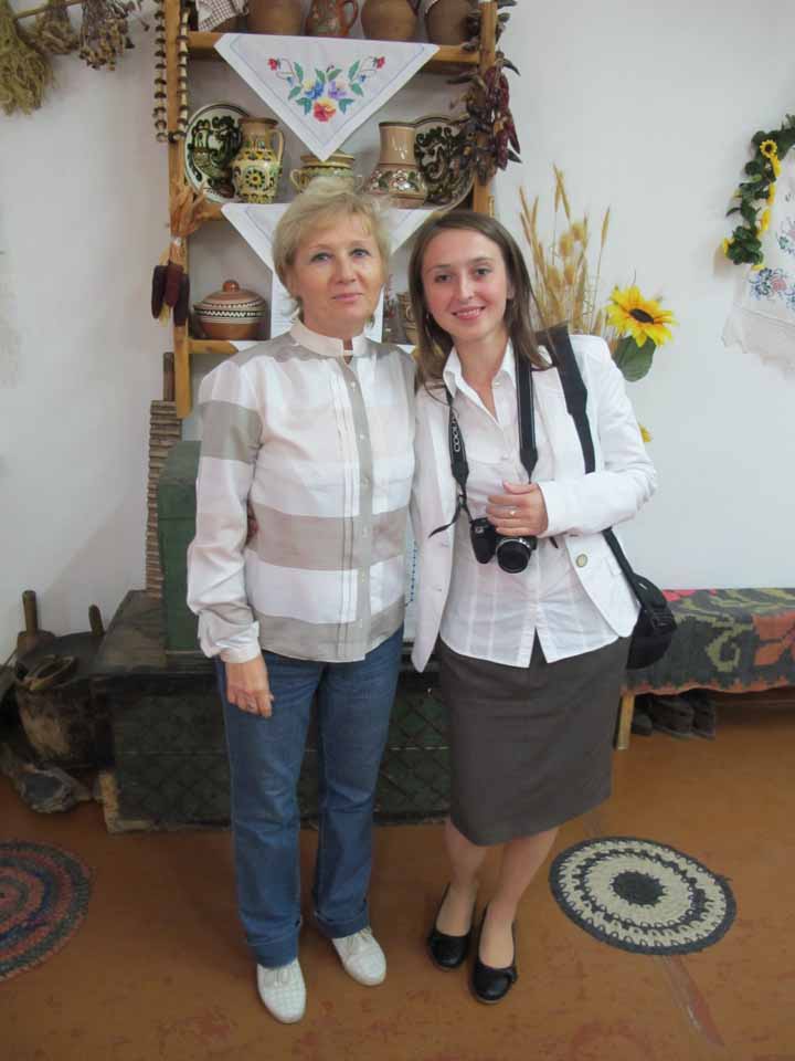 Tamera and Olga in front of display of Ukrainian art and pottery. 