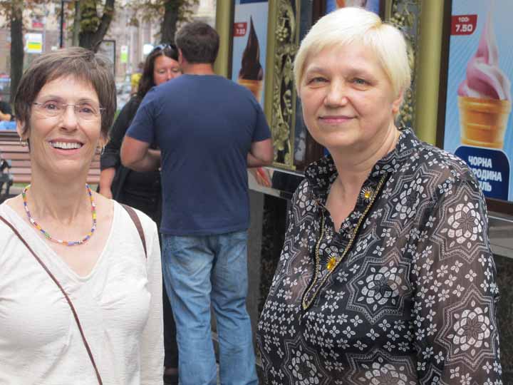 Paula and Lyuba looking at camera outside in the city. 
