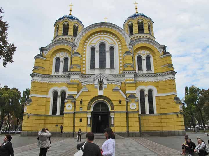 Large yellow church with tall rounded windows and spires. 