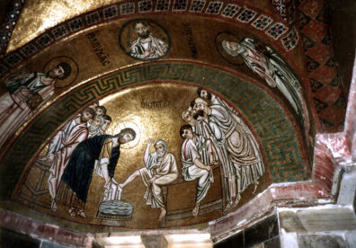 OSSIOS LOUKOS: Mosaic in the main sanctuary depicting Christ washing the feet of the disciples. The heavy outlining and gold background are typical of the Byzantine style. The flash surreptitiously used in this shot (the church was deserted) illuminated Christ's head.