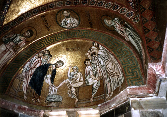 OSSIOS LOUKOS: Mosaic in the main sanctuary depicting Christ washing the feet of the disciples. The heavy outlining and gold background are typical of the Byzantine style. The flash surreptitiously used in this shot (the church was deserted) illuminated Christ's head.