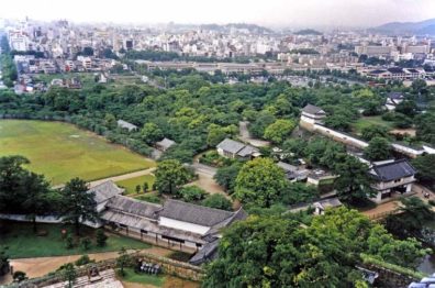 KYOTO: View of the castle grounds from the topmost tower, with the women's quarters in the long, low building on the right. Modern Himeji city in the background. May 25, 1998