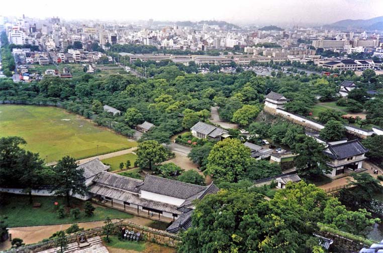 KYOTO: View of the castle grounds from the topmost tower, with the women's quarters in the long, low building on the right. Modern Himeji city in the background. May 25, 1998