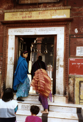 Worshippers entering the sacred temple of Durga ring the bells hanging overhead as they go in.