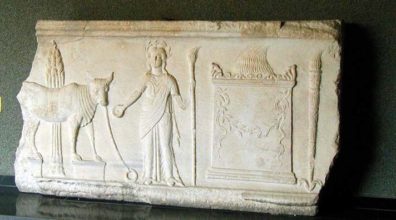 Broken piece of white, flat stone with relief carvings of bull, person and altar.