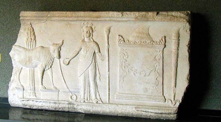 Broken piece of white, flat stone with relief carvings of bull, person and altar.