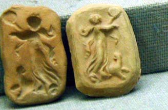 Two small stones that comprise a mold of woman dancing with dog.