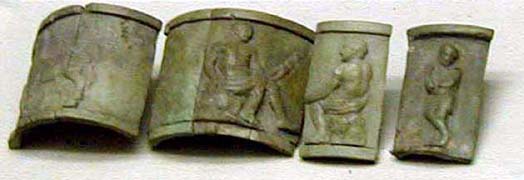 Broken pieces of bronze bracelet illustrated with people and horse.