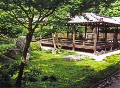 KYOTO: View across a moss garden from one wing of the temple to another. Like other temples, this was originally built as a villa, for the retired Emperor Kameyama; but upon his death in 1291 it was converted to religious uses. Emperors used to be required to retire upon the birth of an heir, which kept the imperial family safely weak and led to a large leisured class of reasonably young retirees. The present buildings are a 17th-century reconstruction, the headquarters of the Rinzai school of Zen. May 26, 1998