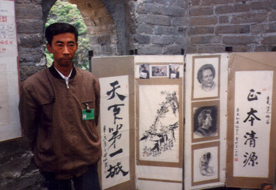 GREAT WALL: Artist at the great wall, displaying drawings of Margaret Thatcher & Sylvester Stallone.