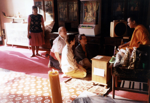 Terry Cook, Deborah Haines, and David Thorndike consult with a Buddhist monk in one of the Wat Po complex temples.