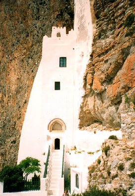 AMORGOS: The stairwell narrowed by the cliff face curving into it.