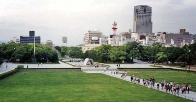 HIROSHIMA: View of the grounds of the Hiroshima Peace Park, site of the world's first atomic bombing (August 6, 1945). Brick crumbled, people evaporated and were burned, and the wood and paper houses were incinerated. Resistance was strong for many years to creating the park, but it is now a center for world peace activities. From the balcony of the museum, facing toward the memorial arch. Rear center is the "peace dome"--the concrete and steel exhibition hall that was directly under ground zero. Just to its left is a huge baseball stadium. In the background, modern Hiroshima. May 17, 1998
