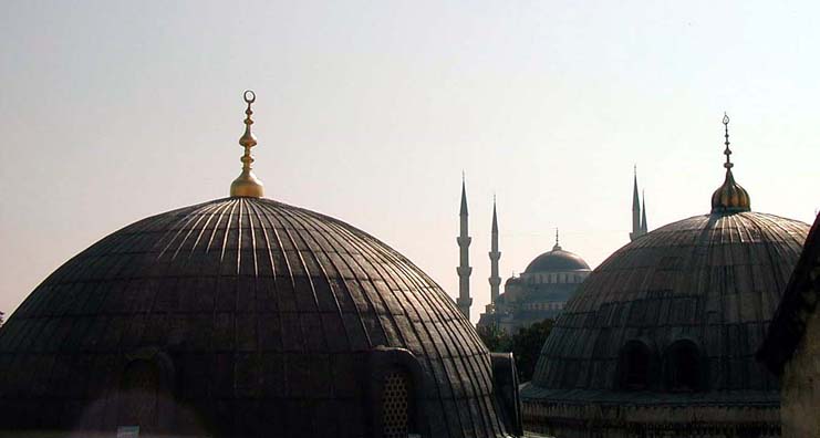 HAGIA SOPHIA: Looking out of an upper gallery window one sees the subsidiary domes of Hagia Sophia in front, and in the distance, the Blue Mosque.
