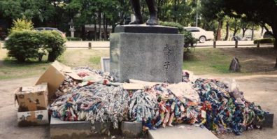 HIROSHIMA: Thousands of folded paper cranes are sent by school children to Hiroshima every day where they are placed on several statues. Here some cartons of them have been rather unceremoniously dumped at the foot of a sculpture of a mother holding her dead children. May 17, 1998