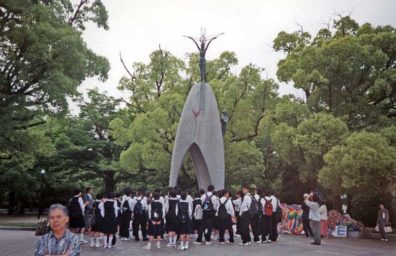 HIROSHIMA: A school group in front of the monument to Sadako, the girl who began the tradition of folding paper cranes. She hoped to regain her health and failed; others imitate her as a symbol of their desire for peace. Note the draped strings of colored paper cranes at right. May 17, 1998