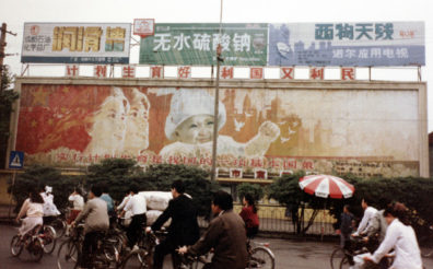 CHENG DU: Billboard uraging one-child population policy. We saw only one family with more than one child: twins. Back in Cheng Du, the Szechuan education commission gave us a lavish banquet, maybe 30-40 dishes, pressing us to sample such delights as pork tendons, fish maw and raw river fish. Some of the group were queasy, but I gamely tried everything. Much of it was delicious. The food in Szechuan was the best on our trip, but the abundance was overwhelming. They always insisted on dining early, 6:40 for this meal. Restaurants close by 8:00. At the feast we were given souvenir vases and beautiful brocade tablecloths from a local silk-weaving factory. At night, went for a walk around a very long block in the dark (there was a planned power outage). In the twilight saw lively street life, including couples dancing on the river bank, children's rides, people lounging outside homes, businesses, mostly lit by candles. One shop had its own generator and light, plus three video games--very popular in China.