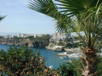 ANTALYA: This view of the Antalya harbor shows the tour boats tied up at the dock below, the spectacular waterfall on the cliffside opposite (look just above the tip of the bush, left), and some of the many hotels that jam this huge tourist center. Germans and other Europeans seeking a seaside getaway at a reasonable price flock here, and Antalya offers the sort of up-scale shopping you'd find on the French Riviera.