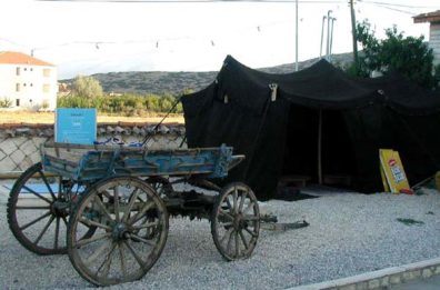 PHASELIS: At another bus stop we spotted this ethnic exhibit: a gypsy cart and traditional tent. Blue plastic seems to be modern equivalent for the migrant workers (mostly women) we saw picking cotton in the fields. Note the ad for Lipton tea.