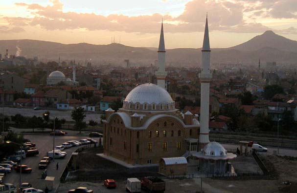 KONYA: Konya is a huge city, and it takes a long time to get from the otogar by taxi (even if your driver is honest--we ran into both kinds in Konya). A very inexpensive green trolley can take you from your bus to downtown, but it's slow and crowded. A good choice for backpackers with plenty of time; but we took a taxi. We chose the luxurious Hotel Bera since we were going to spend only one night. Here's the view out our hotel window at dusk. Konya is a conservative city and not very friendly to tourists (whenever possible, get the hotel staff to summon a cab for you). Most women cover their hair here, unlike in the areas we visited earlier, and many also veiled their faces. We were stared at as oddities on the street and many of the people we dealt with were as grouchy as a New York City cabdriver.