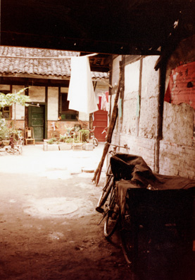 CHENG:DU Typical Cheng Du residential courtyard, set back from the street, with bamboo chair in front of the door.